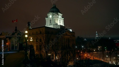 Cinematic Quebec City center Canada cold winter evening night time downtown center Quai Lookout Point St Lawrence River street church peaceful snow on ground flag blowing in wind slow pan a movement photo