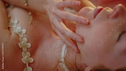 Beautiful young woman in lingerie orgasmically touching her face and moaning