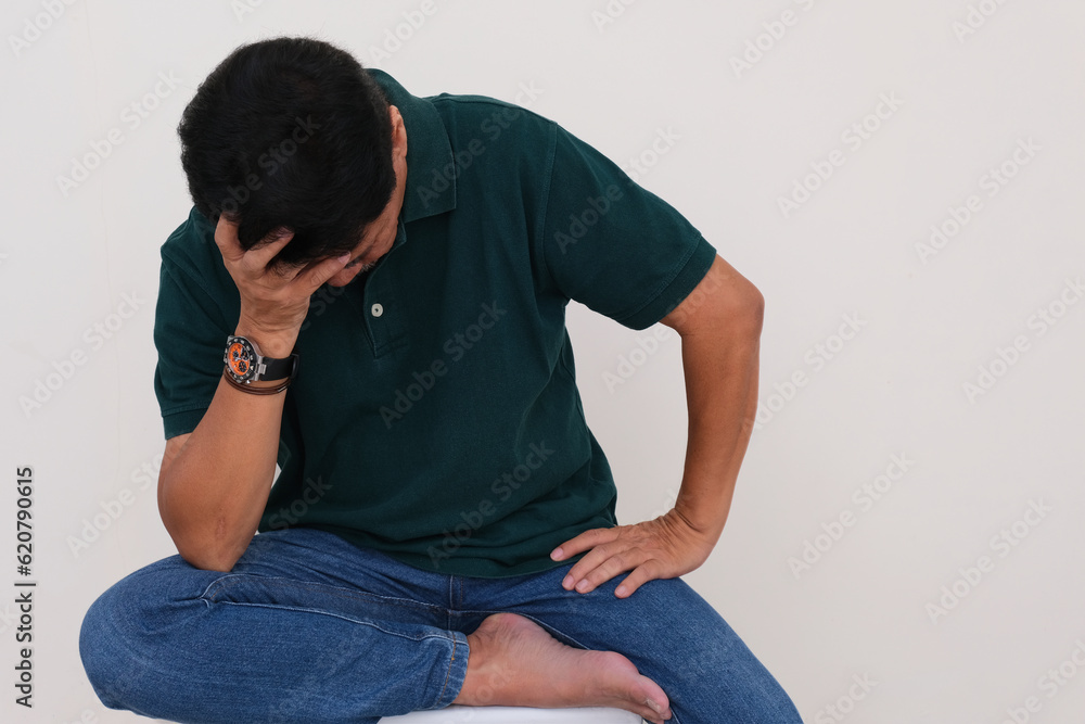Man sitting alone with one hand supporting his face. looking depressed Man sitting alone with one hand supporting his face. looking depressed