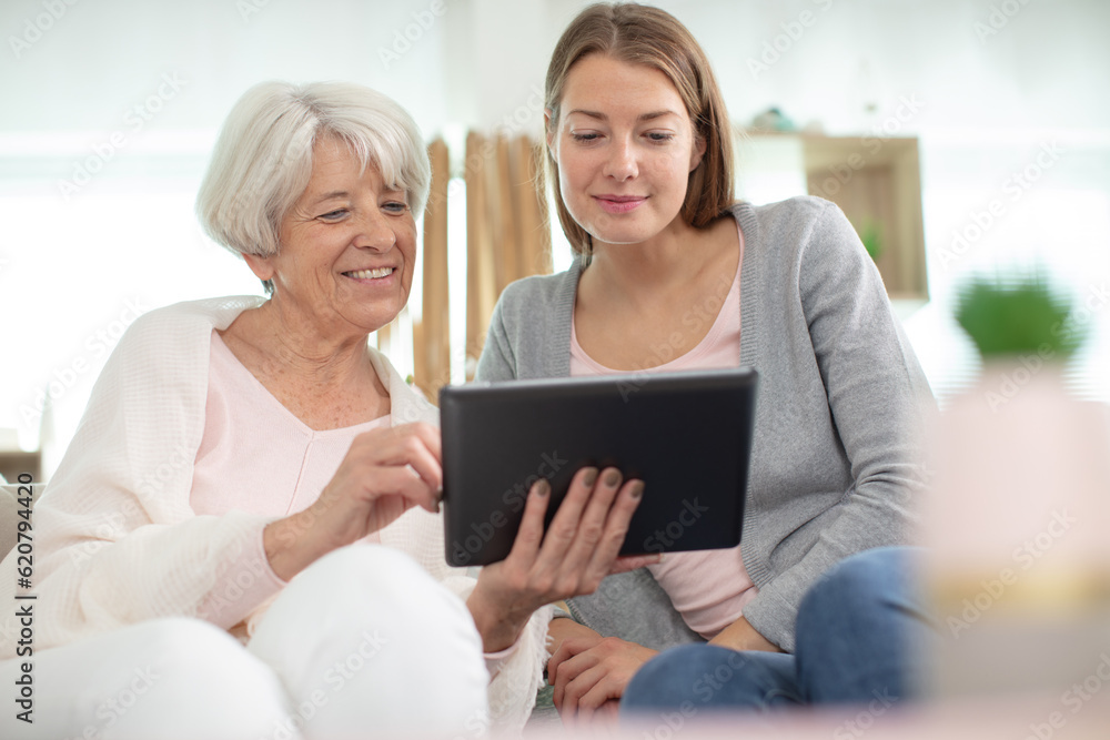 mature mother and her adult daughter using a digital tablet mature mother and her adult daughter using a digital tablet