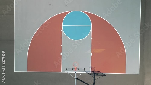 Aerial drone bird's eye view over half of a colorful basketball court on a bright sunny day. 
 photo