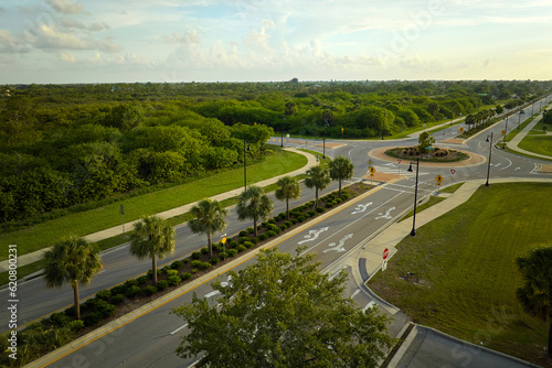 Aerial view of american suburban area with rural road roundabout intersection with moving cars traffic. Circular transportation crossroads in Florida