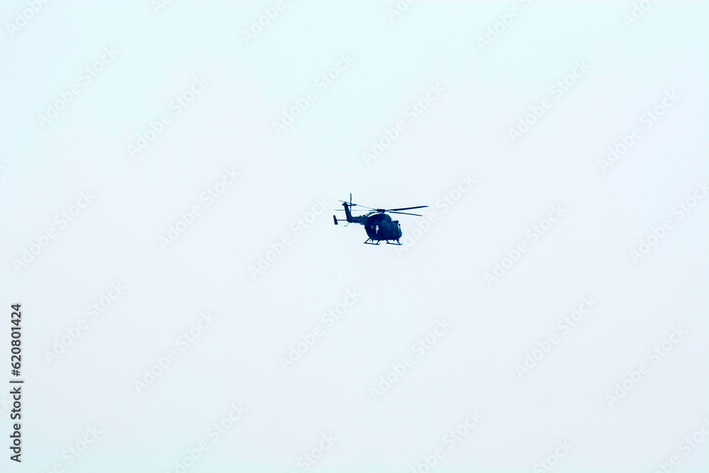 Combat helicopter is flying against isolated blue sky. Combat helicopter attack enemy. Combat helicopter is flying against isolated blue sky. Combat helicopter attack enemy.