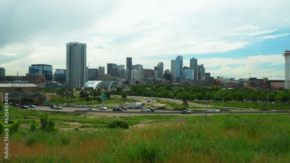 Downtown Denver i25 traffic REI Ball Arena South Platte River Elitch Gardens cityscape with foothills Rocky Colorado cars traffic lush green summer cinematic pan to the left movement Downtown Denver i25 traffic REI Ball Arena South Platte River Elitch Gardens cityscape with foothills Rocky Colorado cars traffic lush green summer cinematic pan to the left movement