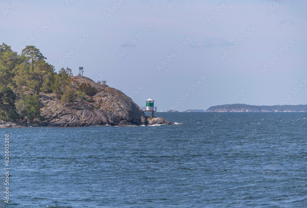 Island, skerries and islet, in the middle part of the archipelago. A ness with a lighthouse and open sea, a sunny summer day in Stockholm