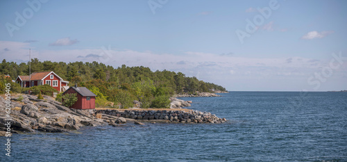 Island, skerries and islet, in the middle part of the archipelago, summer houses, jetties. Houses on a cliff and a stone pier, skyline ocean horizon, a sunny summer day in Stockholm photo