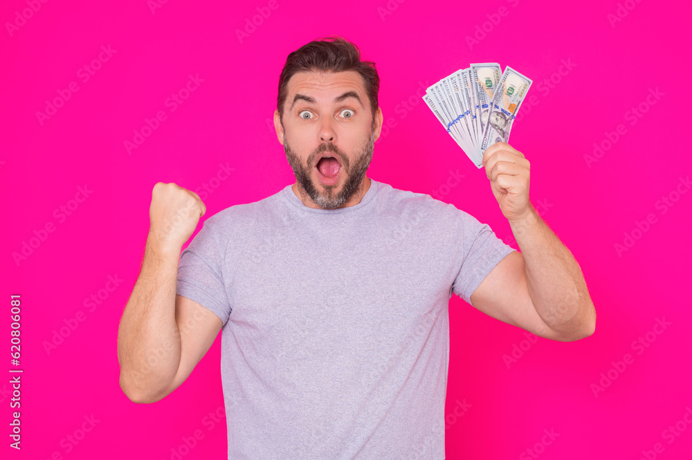 Middle aged hispanic man holding cash money in dollar banknotes on isolated pink background. Studio portrait of business man with dollar banknotes. Dollar money concept. Career wealth business. Middle aged hispanic man holding cash money in dollar banknotes on isolated pink background. Studio portrait of business man with dollar banknotes. Dollar money concept. Career wealth business.