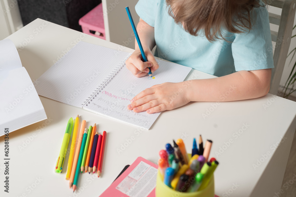 Back to school. Close-up girl draws in a notebook sitting at the table. Distance learning online education. Back to school. Close-up girl draws in a notebook sitting at the table. Distance learning online education.