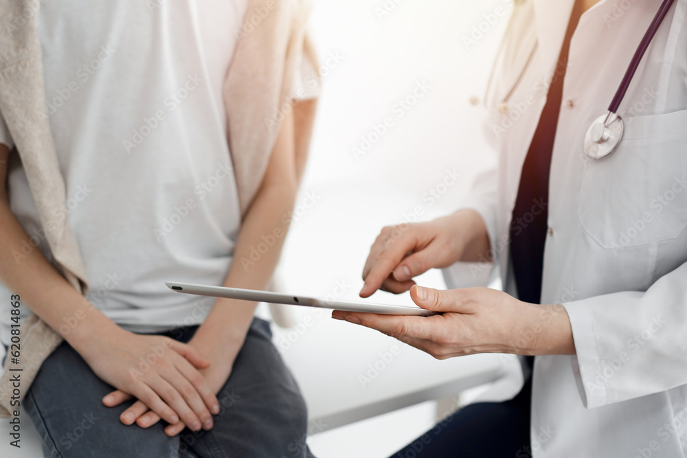 Doctor and child patient. The doctor is using tablet computer and is ready to examine the boy. The concept of ideal health in medicine Doctor and child patient. The doctor is using tablet computer and is ready to examine the boy. The concept of ideal health in medicine