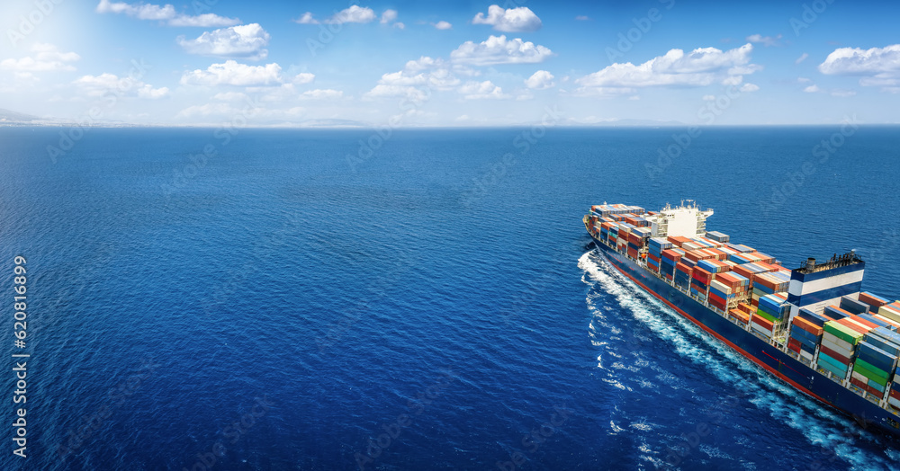 Aerial view of a large cargo ship carrying containers for import and export, business logistic and transportation in open sea with copy space 