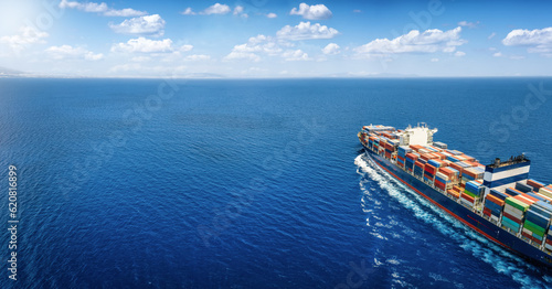 Fototapeta Naklejka Na Ścianę i Meble -  Aerial view of a large cargo ship carrying containers for import and export, business logistic and transportation in open sea with copy space 