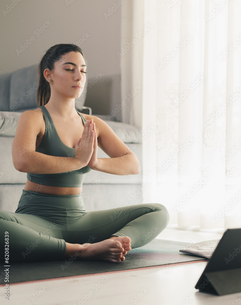 Beautiful young woman doing online yoga at home Beautiful young woman doing online yoga at home