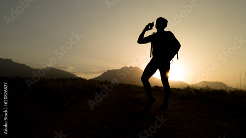silhouette of mountaineer making phone call