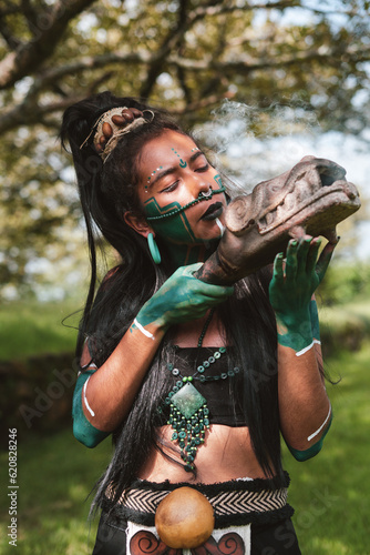 Serious woman warrior with eyes closed holding carved weapon photo