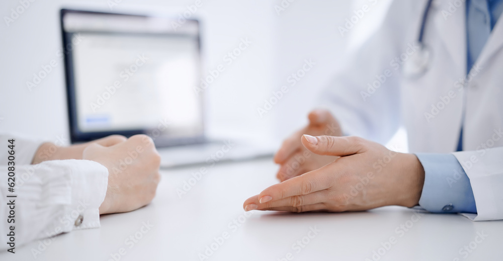Doctor and patient discussing current health questions while sitting opposite of each other at the table in clinic, just hands closeup. Medicine concept Doctor and patient discussing current health questions while sitting opposite of each other at the table in clinic, just hands closeup. Medicine concept