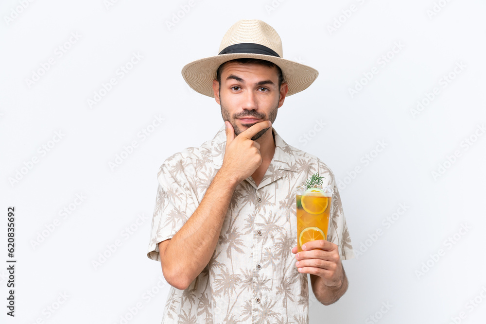 Young caucasian man holding a cocktail isolated on white background thinking Young caucasian man holding a cocktail isolated on white background thinking