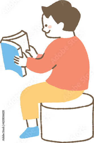 本を楽しそうに読む少年_色