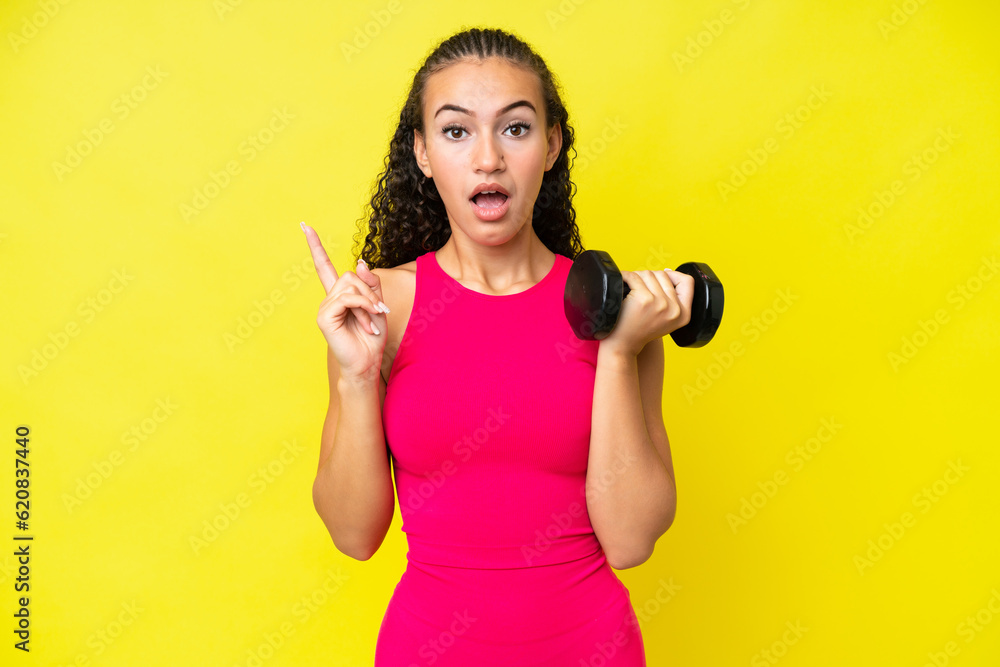 Young sport woman making weightlifting isolated on yellow background intending to realizes the solution while lifting a finger up Young sport woman making weightlifting isolated on yellow background intending to realizes the solution while lifting a finger up