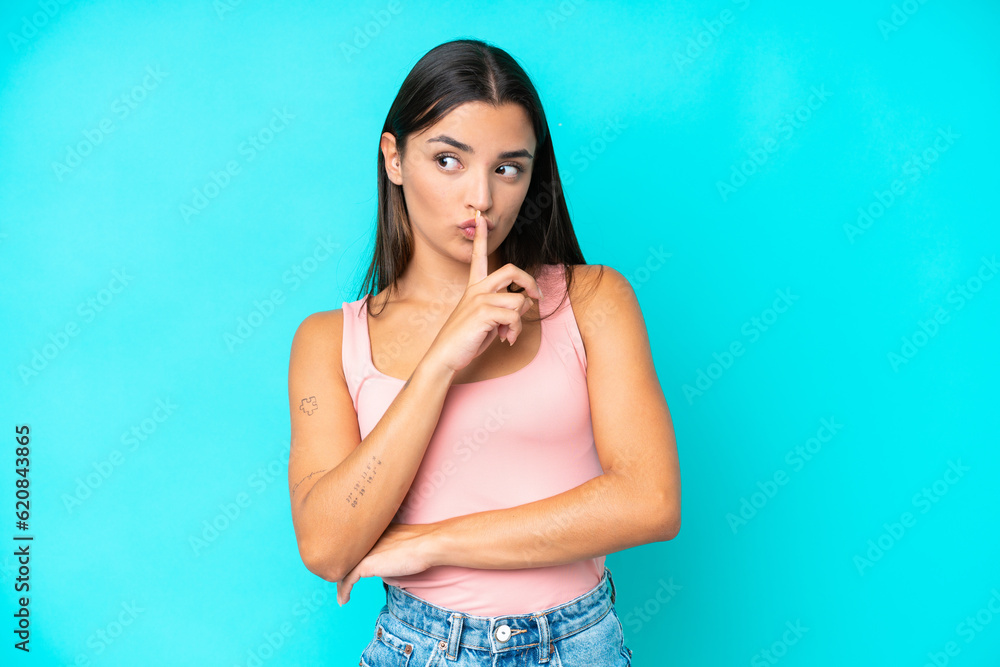 Young caucasian woman isolated on blue background showing a sign of silence gesture putting finger in mouth Young caucasian woman isolated on blue background showing a sign of silence gesture putting finger in mouth
