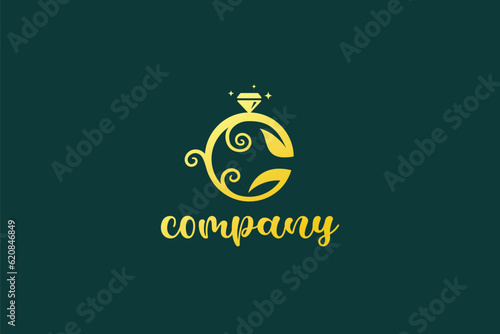 Creative logo design depicting a golden ring with green leaves around it, designated for the fashion or apparel industry.