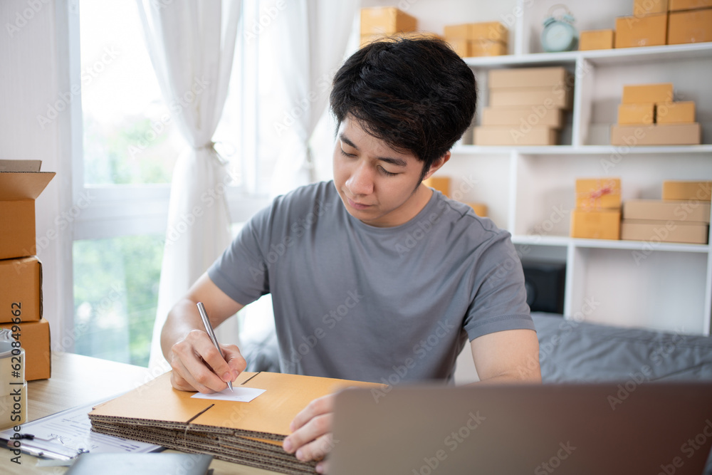 Man Writing Customer Details for Shipping in Home Office, Packing Box and Writing Customer Information for Efficient Shipping, E-Commerce and Online Selling Concept. Man Writing Customer Details for Shipping in Home Office, Packing Box and Writing Customer Information for Efficient Shipping, E-Commerce and Online Selling Concept.