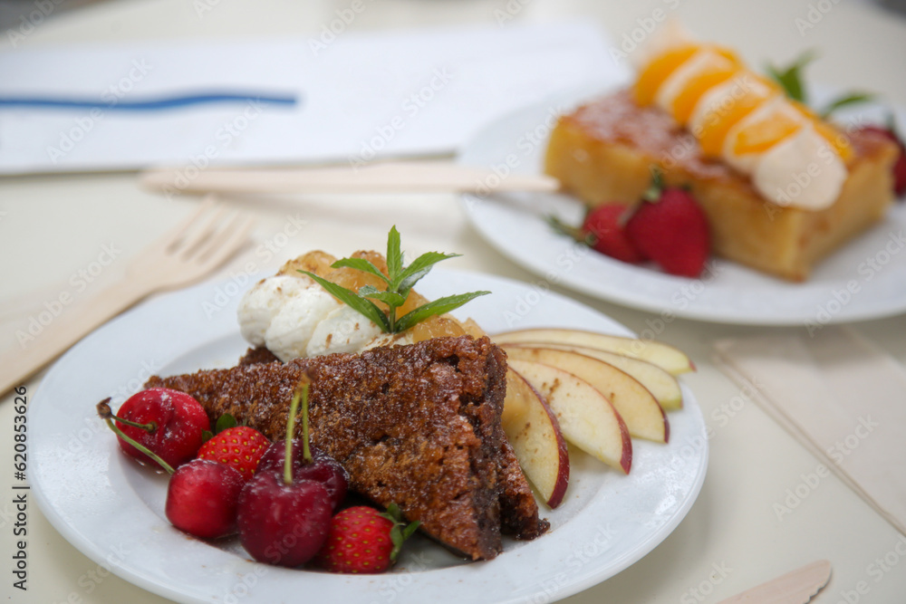 Beautifully decorated slice of cake with fresh fruits on the table in cafe