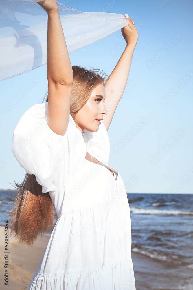 Happy blonde woman is catching clouds and wind with her arms on the ocean beach Happy blonde woman is catching clouds and wind with her arms on the ocean beach