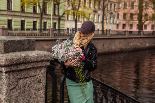 Girl in black cap and leather jacket with pink flowers