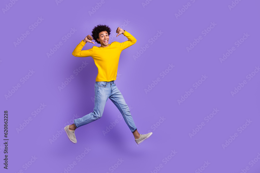 Full body size cadre of young man jumping directing fingers himself best football player achievement isolated on violet color background