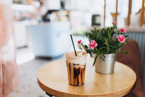 Iced coffee in plastic cup served with whipped cream topping and sweet syrup. Favorite beverage refreshment, sweet drink cafe food menu. photo