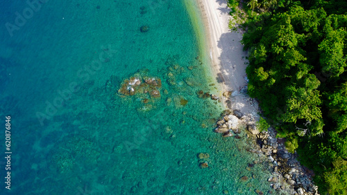 Fototapeta Naklejka Na Ścianę i Meble -  Beach with palm trees. Aerial view of a tropical island. Blue sea, sandy beach, tropical rainforest. Jungle by the sea.