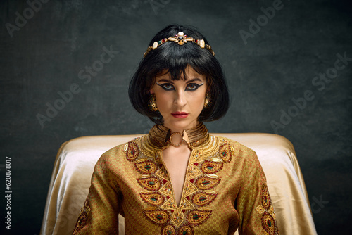 Konstfotografi Close-up portrait of attractive, serious young woman in image of queen, Cleopatra looking at camera against dark vintage background