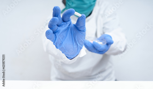 Doctor holding a capsule pill with hand in pharmaceutical research laboratory