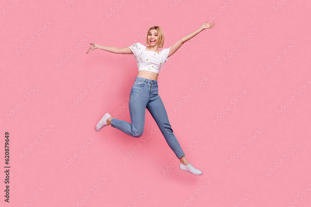 Full length photo of attractive girl jumping energetic have fun hands up running big sale model promoter isolated on pink color background Full length photo of attractive girl jumping energetic have fun hands up running big sale model promoter isolated on pink color background