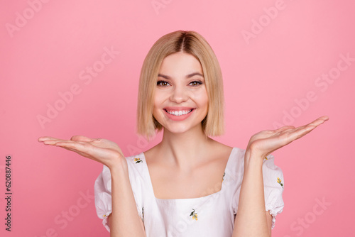 Portrait of attractive lady promoter seller hold both hands showing novelty wear vintage shirt isolated pastel pink color background