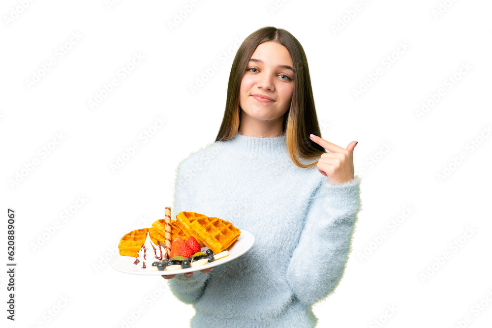Teenager girl holding waffles over isolated chroma key background giving a thumbs up gesture Teenager girl holding waffles over isolated chroma key background giving a thumbs up gesture