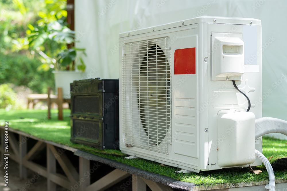 Air conditioner compressor outdoor unit installed outside the geodesic dome tent for camping in resort hotel. Air conditioner compressor outdoor unit installed outside the geodesic dome tent for camping in resort hotel.