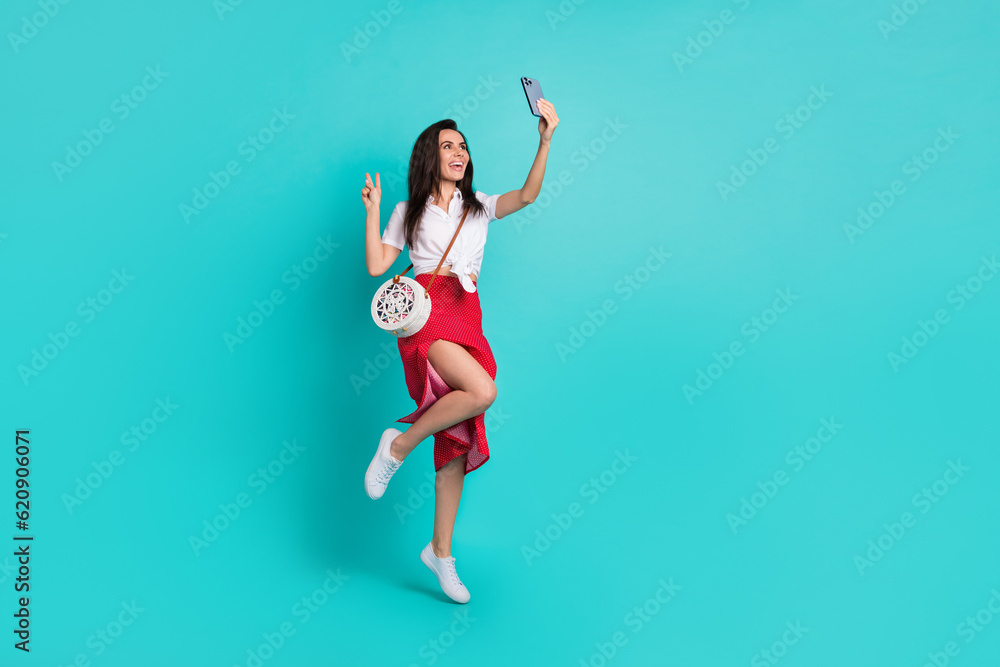 Photo of cute charming lady dressed white crop top purse recording video vlog modern device empty space isolated turquoise color background Photo of cute charming lady dressed white crop top purse recording video vlog modern device empty space isolated turquoise color background