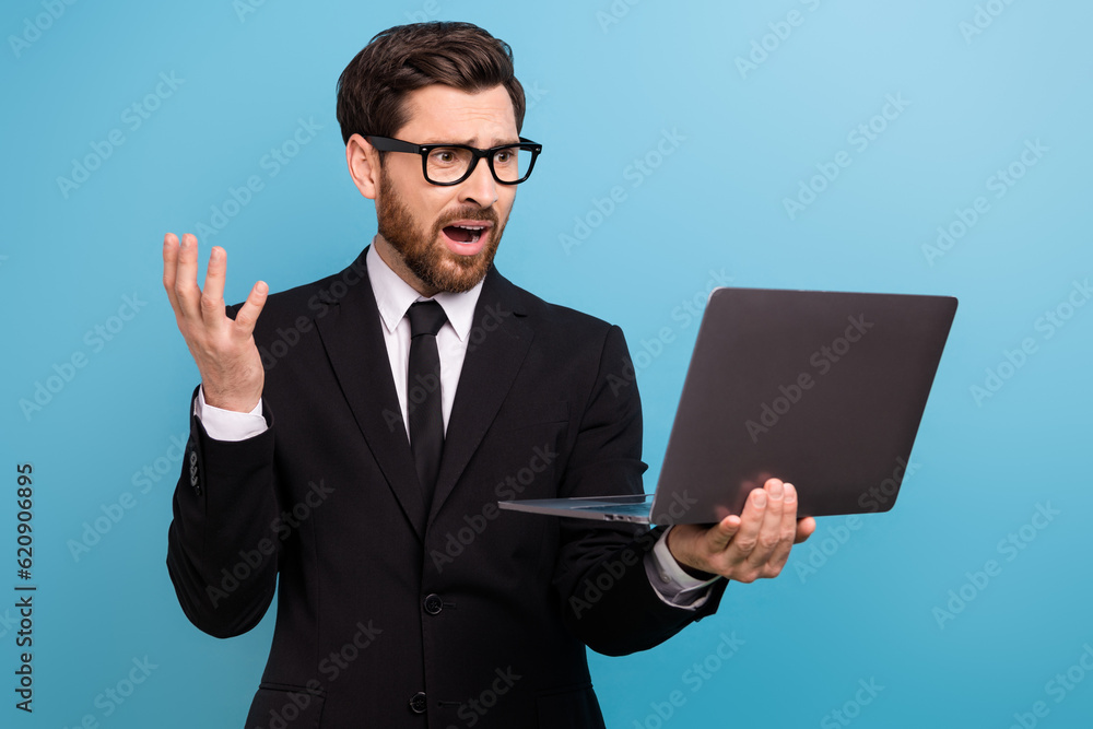 Photo of angry shocked boss wear black tuxedo spectacles reading failed report modern gadget isolated blue color background Photo of angry shocked boss wear black tuxedo spectacles reading failed report modern gadget isolated blue color background
