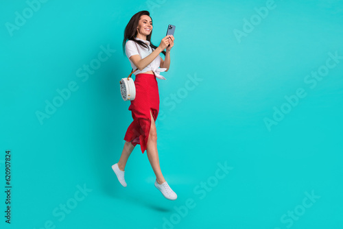 Photo of sweet cute girl wear white tied shirt handbag chatting twitter telegram facebook empty space isolated teal color background