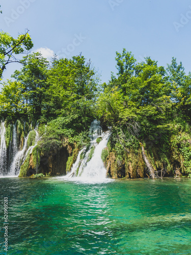 Enormous waterfall with green tones and blue water in Plitvice Lakes National Park 