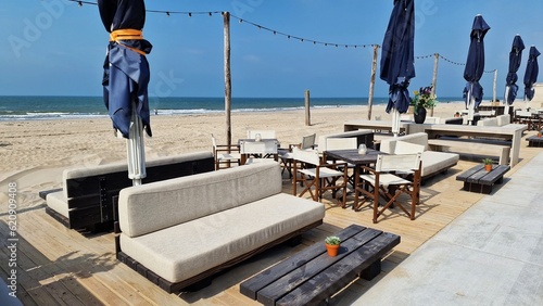 Tables, chairs and couches, on the North Sea beach in Kijkduin, Netherlands. Cafe on the beach in summer day. photo