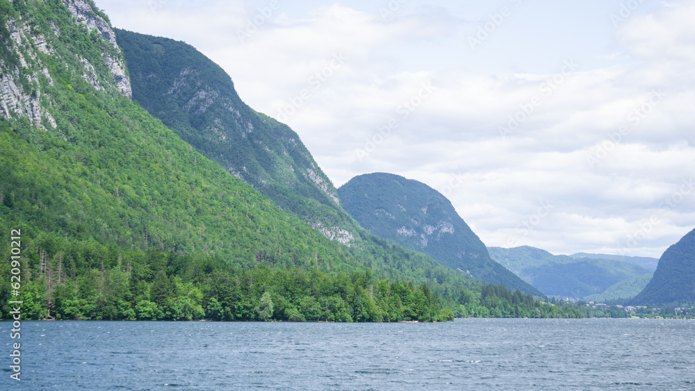 Fototapeta premium Beautiful panorama of a lake with green mountains on a cloudy day