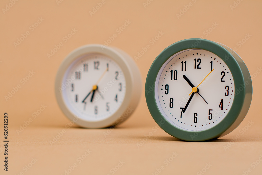 Alarm clock. Beautiful modern clock lies on paper background. time clock time standstill time off work working with time time concept Alarm clock. Beautiful modern clock lies on paper background. time clock time standstill time off work working with time time concept