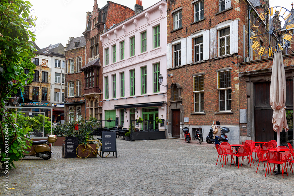 Old street with tables of cafe in historic city center of Antwerpen (Antwerp), Belgium. Cozy cityscape of Antwerp. Architecture and landmark of Antwerpen
