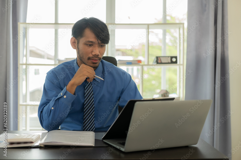 Young african man working with analytics sitting in beautiful workplace with laptop computer and financial report analysis concept document. monthly account Young african man working with analytics sitting in beautiful workplace with laptop computer and financial report analysis concept document. monthly account