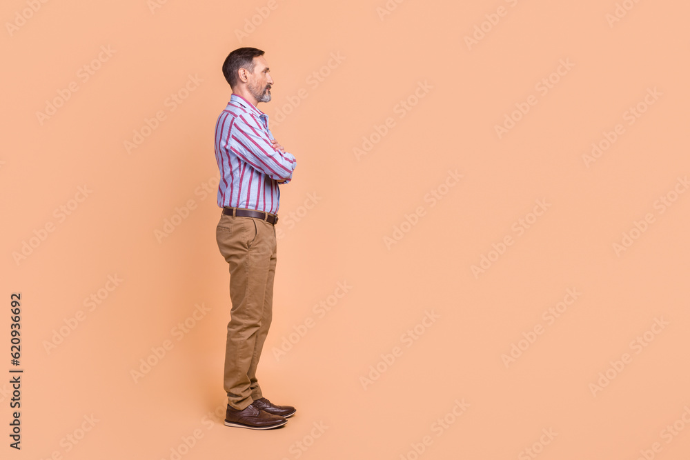 Side profile photo of serious person dressed colorful shirt arms folded look at offer empty space isolated on pastel color background Side profile photo of serious person dressed colorful shirt arms folded look at offer empty space isolated on pastel color background