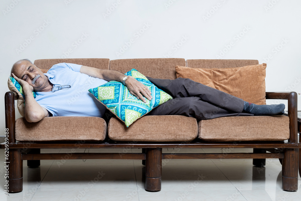 Indian senior man taking rest at sofa at living room. Senior man laying off at sofa Indian senior man taking rest at sofa at living room. Senior man laying off at sofa