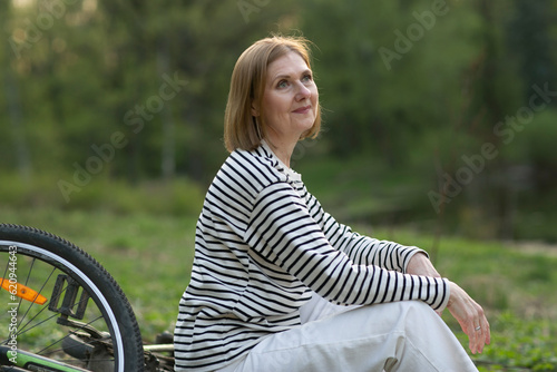  woman in leather jacket with bicycle closeup photo on spring sunset background