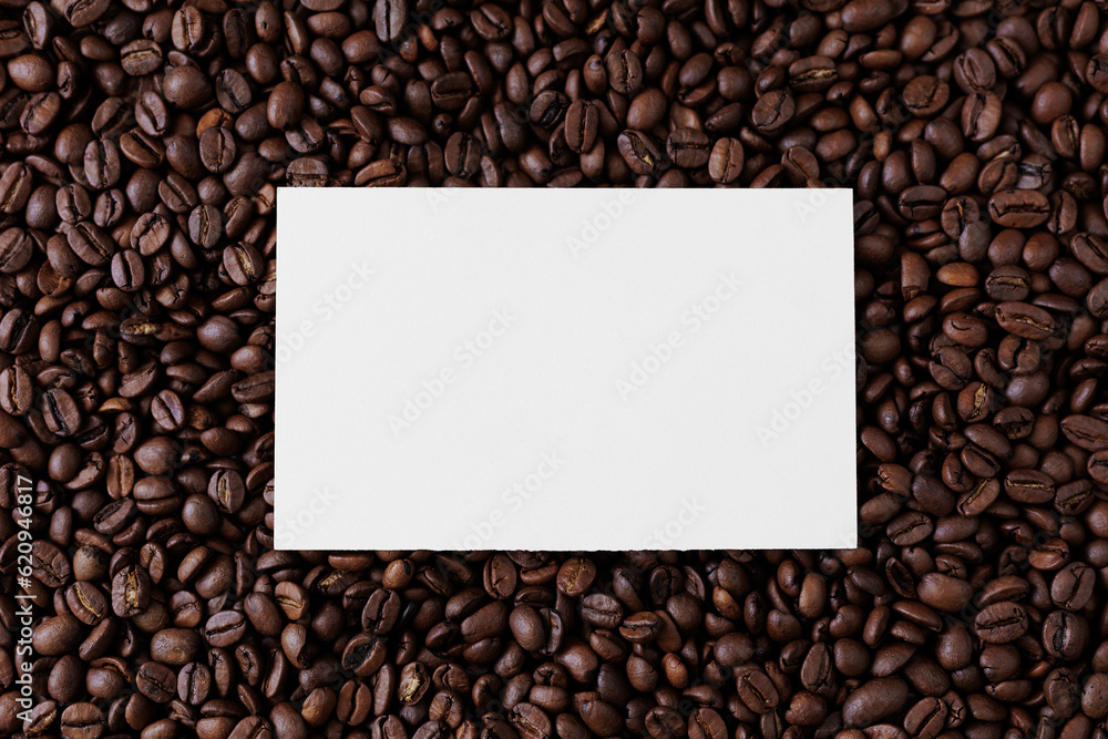 Top view of blank paper card on dark background from coffee beans Top view of blank paper card on dark background from coffee beans